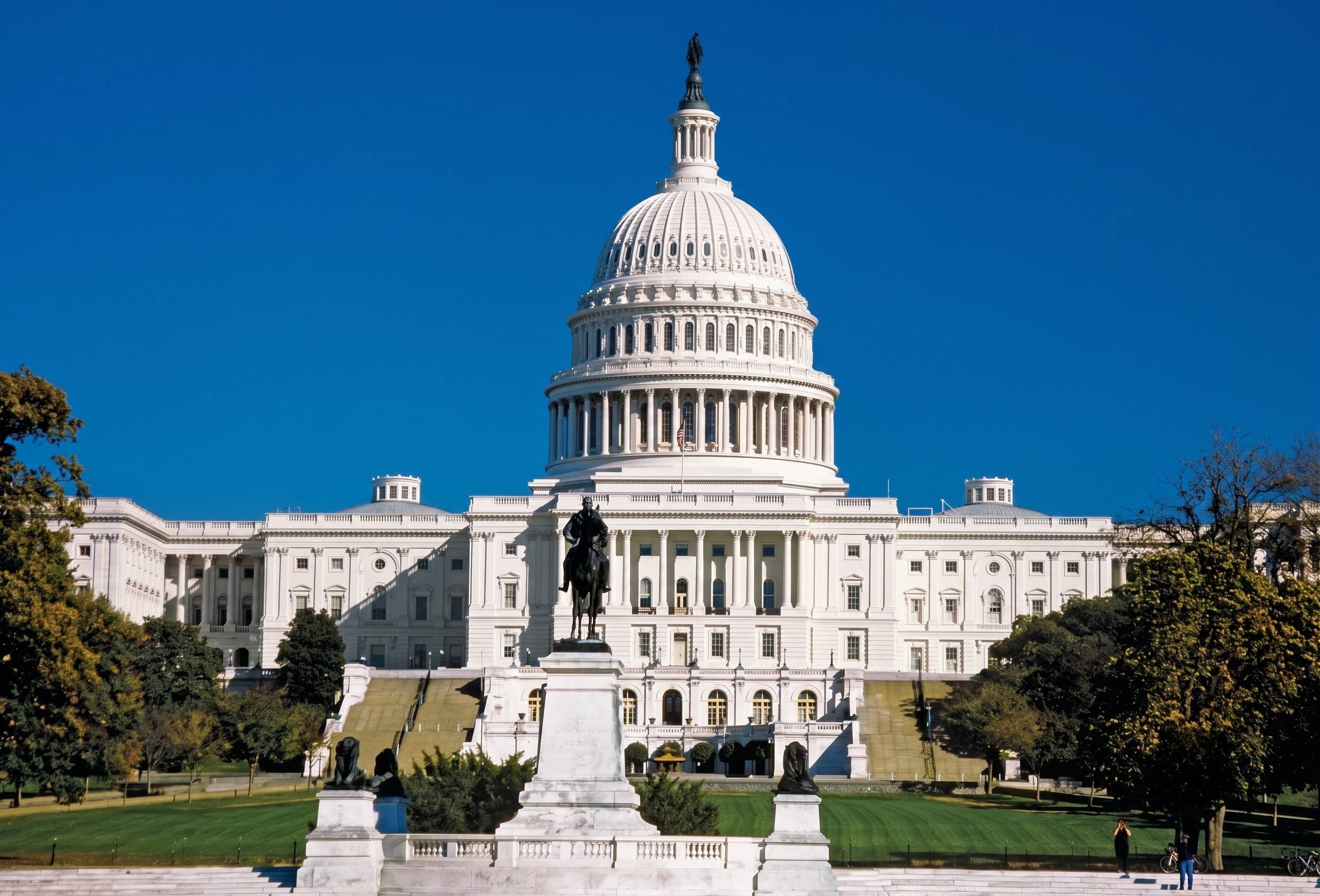 Capitol Building In Front Of A Black Metal Statue