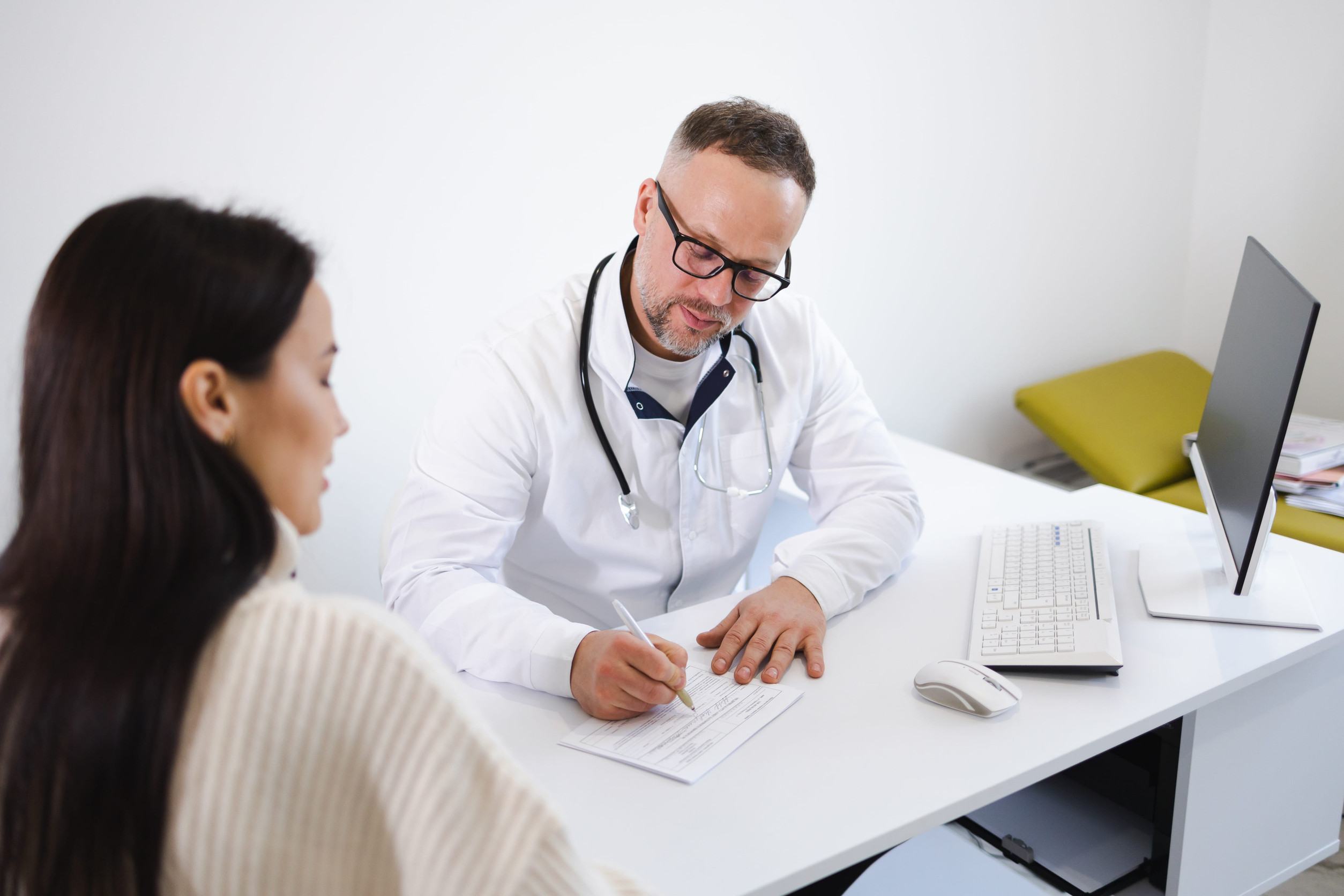 Doctor Writing Prescription To A Patient
